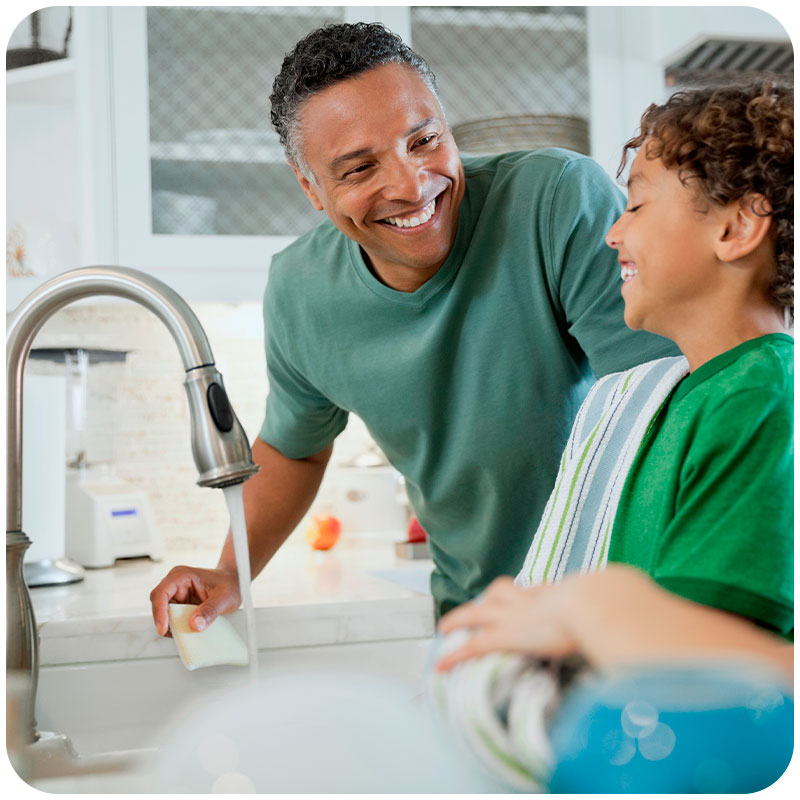 A young man and a boy laughing with a clean water